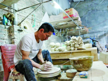 Image: Artisan diligently preserves ancient pottery