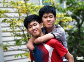 Image: Brotherly love in Vietnam: Twin acts as arms, legs of younger brother