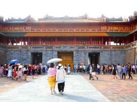 Image: Tourists cover up a mask to visit the ancient capital of Hue
