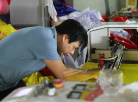 Image: The family of three generations sews the national flag