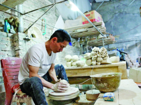 Image: Artisan diligently preserves ancient pottery