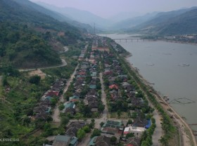 Image: Street of houses on stilts with stone roofs by the Da River