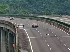 Image: Woman Steps Out of Car and Lies Down on Highway