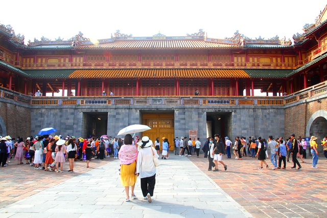 Tourists cover up a mask to visit the ancient capital of Hue