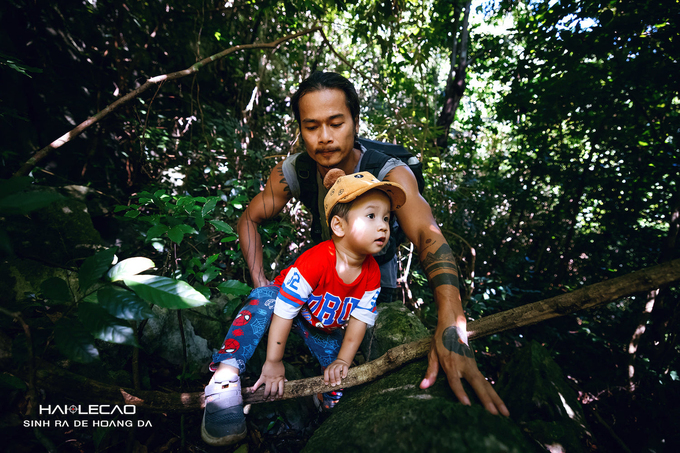 A 22-month-old boy with his father trekking in Cat Ba forest