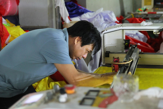 The family of three generations sews the national flag