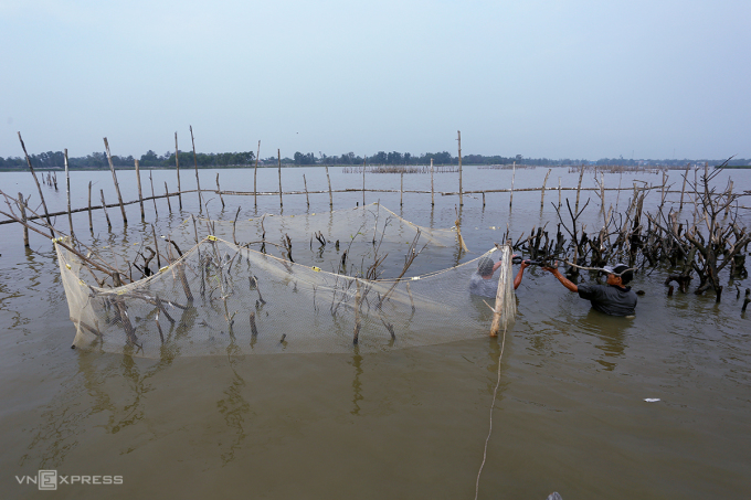 Unloading poles to catch fish on Dam river